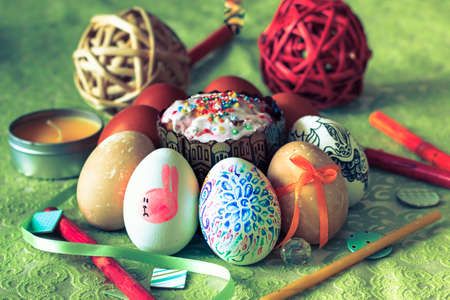 Painted easter eggs on green floral background in rustic style. Easter concept. Vintage color tone.