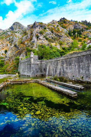 Mediterranean landscape. Overhanging cliffs, medieval city walls and river.の写真素材