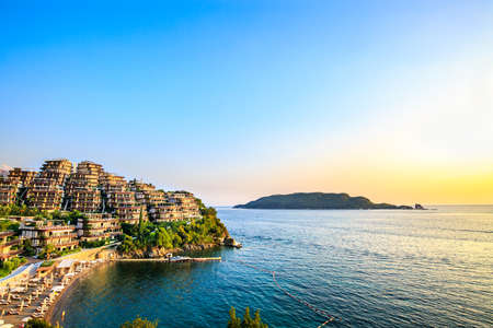 Dukley Gardens - elite real estate along the Adriatic sea coast, has modern villas and luxury apartments. Rich resort on sunset, hotel seaside, beach in Budva marina, Montenegro. Wealthy summer vacation.の写真素材