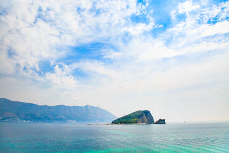 Seascape with desert island in blue heavens.