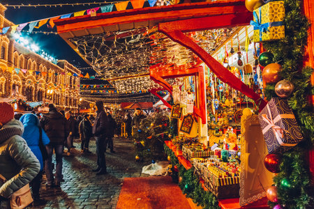 Moscow, Russia - January 1, 2018: Illuminated Christmas market in the winter season. People shopping traditional gifts in Red Square near State Department Store. Christmas fair at night.のeditorial素材