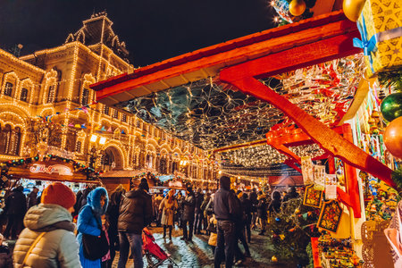 Moscow, Russia - January 1, 2018: Illuminated Christmas market in the winter season. People shopping traditional presents in Red Square near GUM State Department Store. Christmas fair at night.のeditorial素材