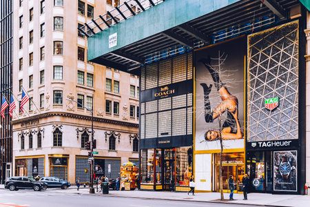 New York, USA - February 8, 2020: TAG Heuer store and Coach fashion house on iconic shopping street in winter. Typical crossroad on Fifth Avenue. Pedestrians passing crosswalk. Touristic place.のeditorial素材