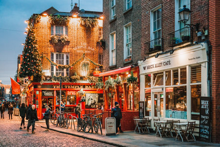 Dublin, Ireland - November 8, 2018: Famous Temple Bar. Christmas tree, illumination and decorations above entrance. Vintage terrace with empty coffee table. lifestyles.のeditorial素材