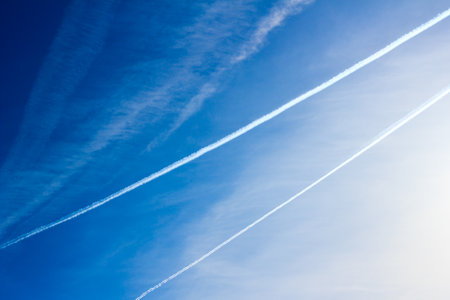 Cloudscape with trail of jet plane on blue sky. Natural background.の写真素材