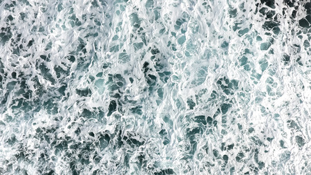 Aerial view of the foam, spray and turquoise sea water.View from above of the ocean.