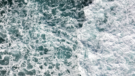 Aerial view of the foam, spray and turquoise sea water.View from above of the ocean.