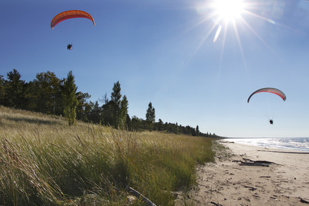 Two Motorized Hang Glider Kites Being Piloted Over Secluded Lake Huron Beach - Grand Bend, Ontario,...