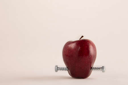 Apple with bolts  a metaphor about genetically modified foodの写真素材
