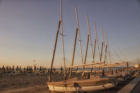 bathhouse and sailing boats on the seaside near the harbour channel of Cervia in Northern Italy on...