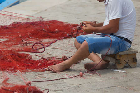 Fisherman repairs his net in Gallipoli (Le)の写真素材