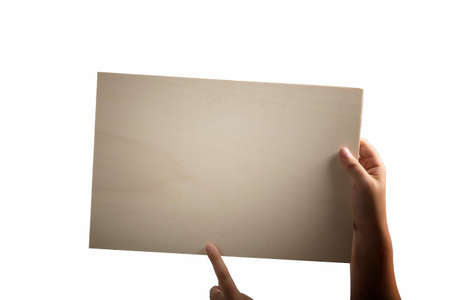 A light colour plywood square blank sign supported by young hands on light backgroundの写真素材