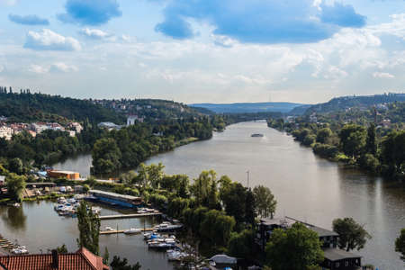 View of Prague from the Vltava river: house, trees, buildings and historical palaces
