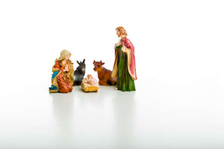 A simple Christmas Crib where the little statues represent the Holy Family, the Virgin Mary, Saint Joseph and the infant Jesus, watched by ox and donkey during the night of the 25th of Decemberの写真素材