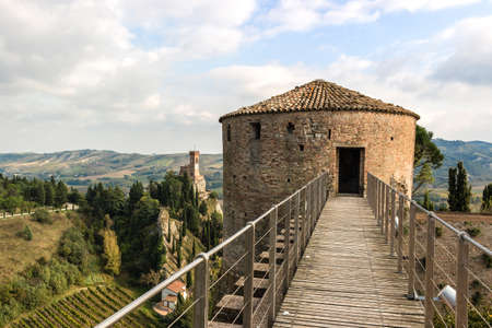 The brickwalls of the medieval Fortress of Venetians in Brisighella. Cultivated fields and the Clock Tower in the backgroundのeditorial素材