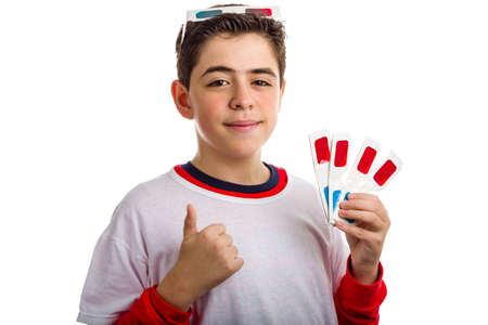 A hispanic boy wears a pair of 3D Cinema paper eyeglasses on his head with red and sky-blue lenses...