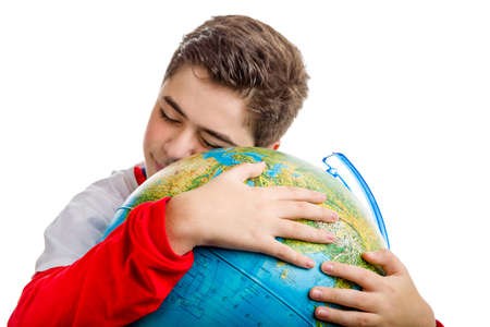 A Caucasian boy smiling hugs a globe revealing only the closed eyes and part of the faceの写真素材