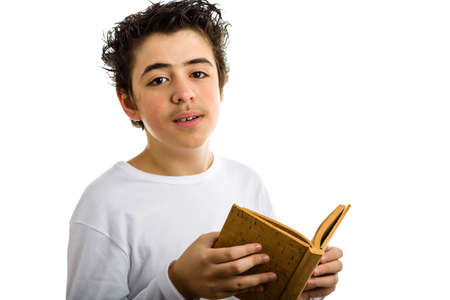A handsome Hispanic boy reads with serene eyes a brown blank book made with corkの写真素材