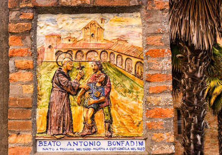 The fresco represents the meeting of the Catholic Blessed with a man and his suffering son, probably  during an exorcism: itâs at the entry of the garden of the XV century roman gothic church dedicated to Saint Francis in Cotignola in Italyのeditorial素材