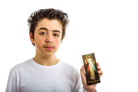 A hispanic boy holds a picture of Merciful Jesusの写真素材