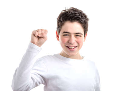 Latin smooth-skinned boy in a white long sleeved t-shirt smiles making a gesture of power raising...