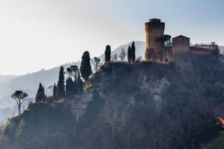 The brick walls of a medieval fortress and a sanctuary devoted to Blessed Virgin on hills in the countryardのeditorial素材