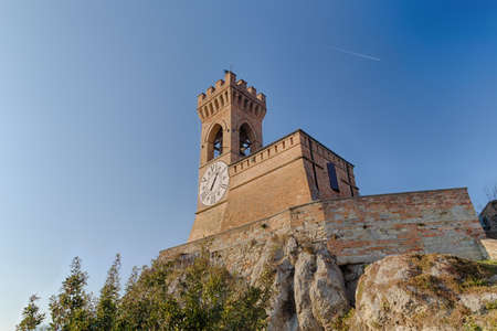 A  medieval crenellated brick wall clock tower in a sunny winter dayの写真素材