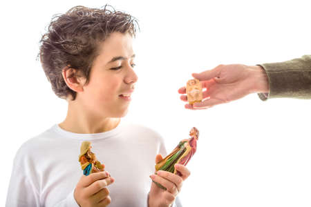 A calm and confident Hispanic boy with soft and smooth skin while holding crib statues, the Blessed...