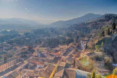 Tile roofs of Italian country village in a winter foggy and sunny dayの写真素材