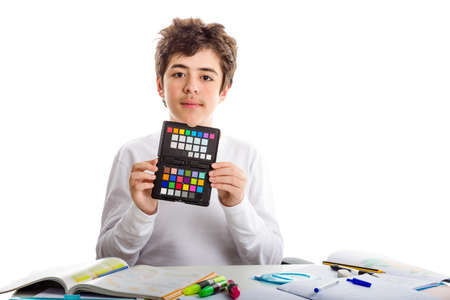 Acne Caucasian teenager boy holding a checkerboard of colors on black signboard with both hands while doing  homeworkの写真素材