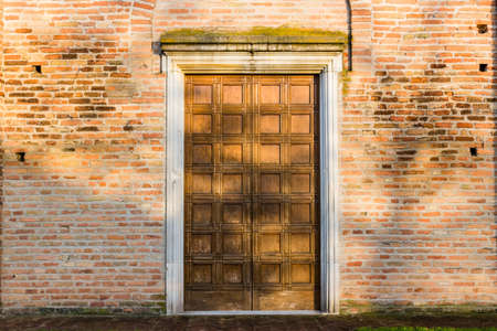 Wooden door entry of the Facade of the VII Century Saint Peter in Sylvis parish church in Italyの写真素材