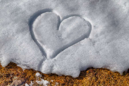 A heart drawn by hand in the fresh snowの写真素材