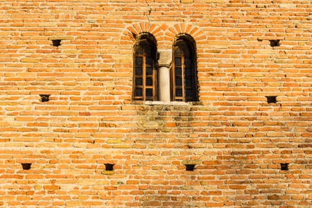 mullioned window of the Facade of the VII Century Saint Peter in Sylvis parish church in Italyの写真素材
