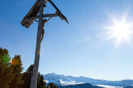 A wood carved statue  of the Crucifixion of Jesus Christ on top of the dolomites alpsの写真素材