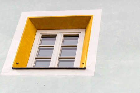 Squared glass window with white frame and simple yellow borderの写真素材