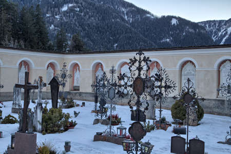 Catholic cemetery on high mountains overlooking snowy peaks and pine forest