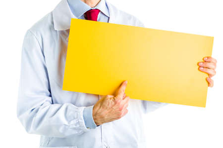 Caucasian male doctor dressed in white coat, blue shirt and red tie is showing a blank yellow...