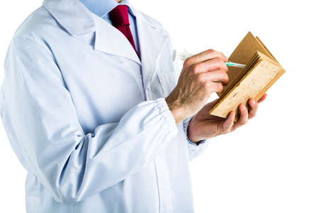 Caucasian male doctor dressed in white coat, blue shirt and red tie is writing in a blank cork book...