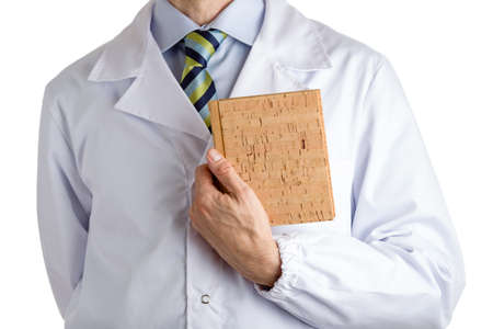 Man dressed with medical white coat, light blue shirt and glossy regimental tie with dark blue, light blue and green stripes, is holding a blank cork bookの写真素材