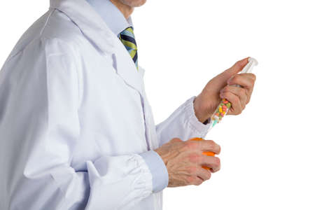 bust of a man wearing medical white coat, light blue shirt and glossy regimental tie white dark blue, light blue and green stripes, and makes an injection to orangeの写真素材