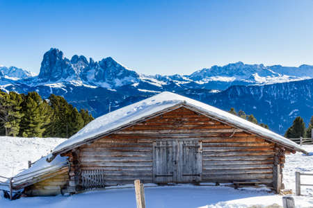 panorama of the Dolomites with wood cottage,  snow-capped peaks and green conifersのeditorial素材