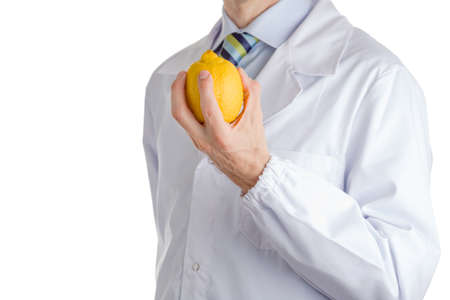 bust of a man wearing medical white coat, light blue shirt and glossy regimental tie white dark blue, light blue and green stripes, and showing yellow lemon  with left handの写真素材