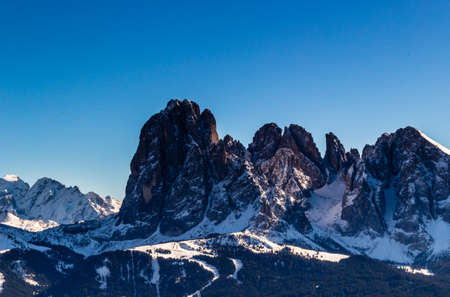 panorama of the Dolomites with snow-capped peaks and green conifersの写真素材