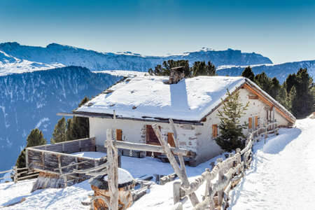 panorama of the Dolomites with wood cottage,  snow-capped peaks and green conifersのeditorial素材