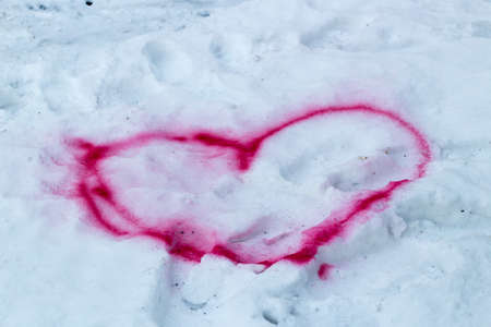 Red heart drawn in the snowの写真素材