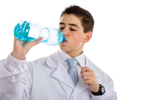 A boy doctor in blue tie and white coat with black digital watch drinking water from plastic bottle. His acne skin has not ben retouchedの写真素材