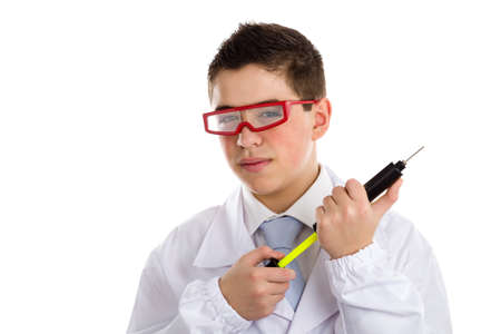 A boy doctor with acne skin in white coat wearing red googles and holding a black pump syringe helps to feel medicine more friendlyの写真素材