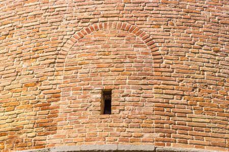 ancient brick walls with window of military fortification of 1400 in Northern Italy in Emilia...
