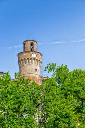 Clock tower with brick walls guarding a countryside village in Italyの写真素材