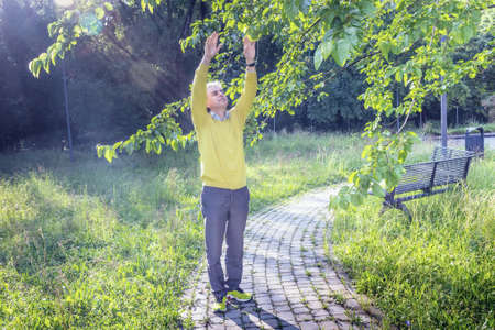 Handsome middle-aged man with salt pepper hair, medium hair, dressed in casual clothing with yellow...